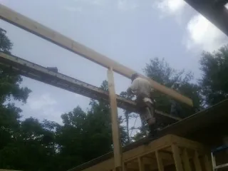 Carpenter setting a ridge beam over a new addition frame — Ice Dam Removal by Roofing Brothers in Fischer