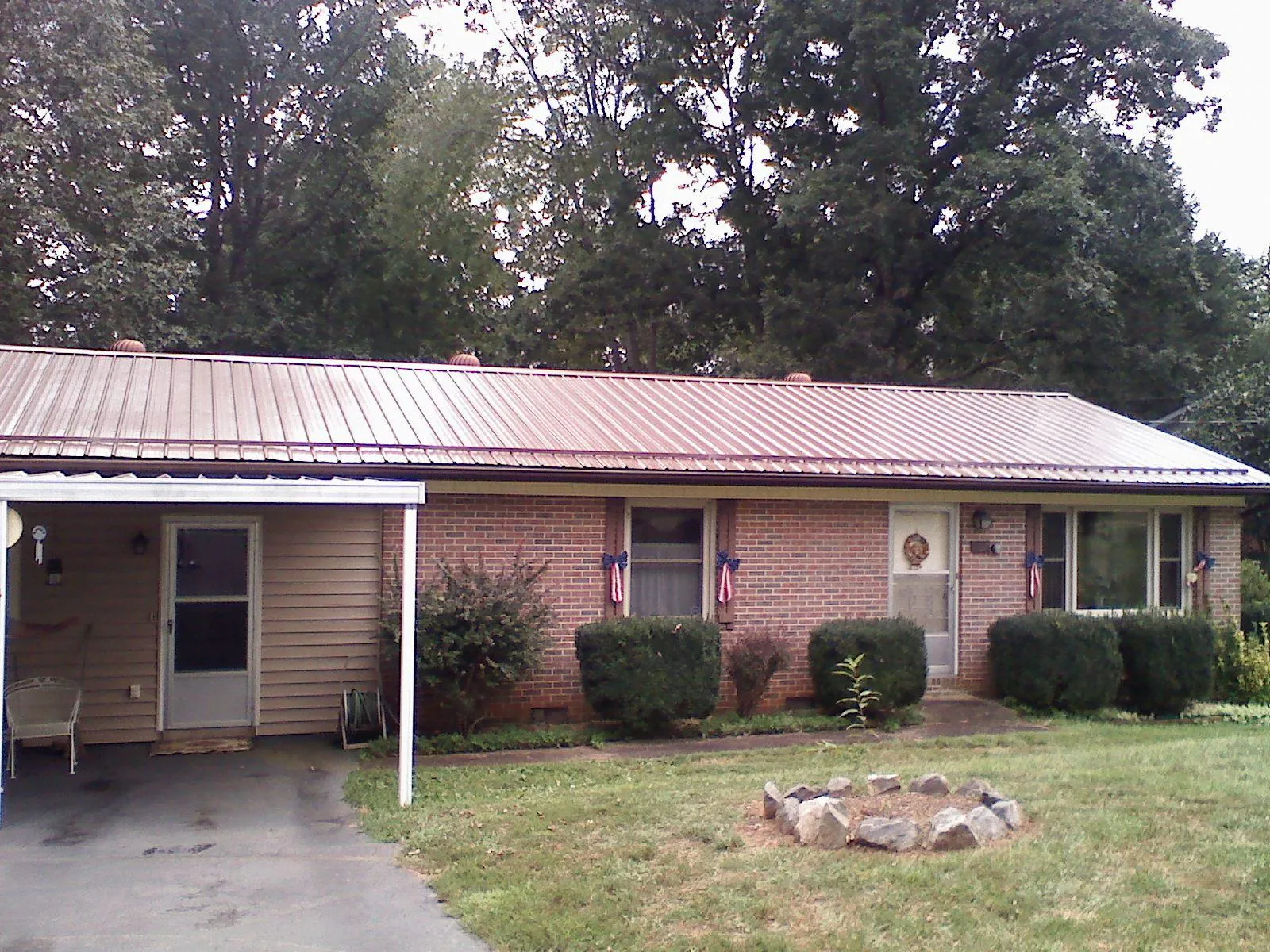 Bronze metal roof and carport on a brick ranch home — Roof Repair work by our crew in Fischer